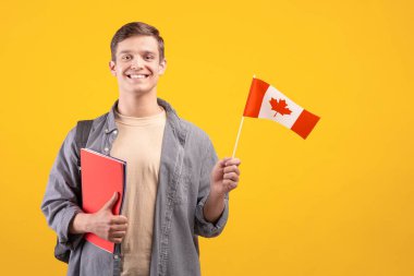 Kanada günü, vatanseverlik ve bilgi paylaşımı. Sırt çantası, not defteri ve küçük bayraklı, turuncu arka planda izole edilmiş, kesilmiş, kopyalama alanı, stüdyo çekimi