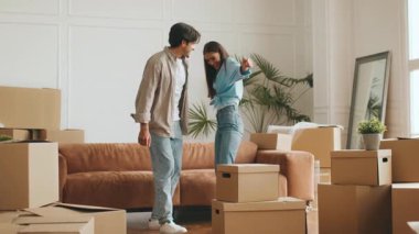 Bir çift, taşınan kutular ve rahat bir kanepe ile çevrili yeni evlerindeki kutuları boşaltıyor. Birlikte yeni bir hayata başlayacakları için çok heyecanlılar..