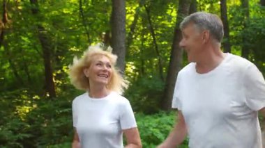 Bereketli yeşil bir parkta, yaşlı bir çift yan yana koşu yapıyor, gülüşmeler ve kahkahalar atıyorlar. Neşeli aktiviteleri, 60 'larında canlı ve aktif bir yaşam tarzını vurguluyor..