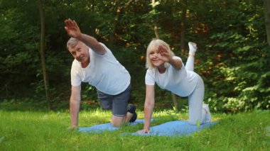Üst düzey bir çift spor yapıyor, spor yapmaya ve sağlıklı olmaya olan bağlılıklarını gösteriyorlar. Onların neşeli ifadeleri doğada aktif kalmanın faydalarını vurgular..