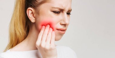 Diş ağrısı. Sinirli genç kadın yanak dokunmadan ve gözleri kapalı tutmak, panorama