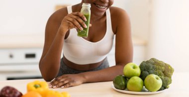 Sağlıklı beslenme. Afrika 'lı Sporcu Kadın, evde modern mutfakta durup kilo vermek için meyve suyu içiyor. Zayıflama, Yeme ve Sağlık İçin Detox Diyet, Kilo Verme Yaşam Tarzı Konsepti
