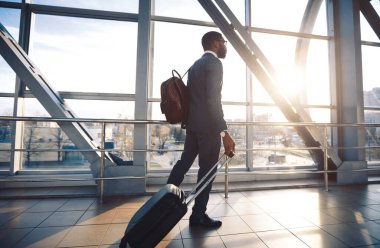 Havalimanı Terminali 'nde seyahat çantasıyla yürüyen siyah girişimci. Tam Uzunluk, Boş Alan