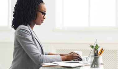 Ofis işi. İş yerinde dizüstü bilgisayar kullanan siyah kız. Boşluğu Kopyala, Yan Görünüm