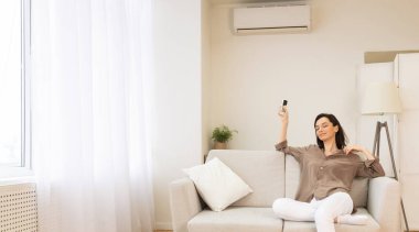 Yaz havasına hazır ol. Sakin bir kızın klimayı açması evdeki koltukta dinlenmesi, fotokopi odası.