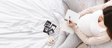 Doğuma hazırlanıyorum. Hamile kadın doğum hastanesi, üst görünüm, boş alanı olan panorama için paketleme listesi yapıyor.