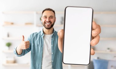 Tavsiye mektubu. Elinde beyaz ekranı olan akıllı telefonu tutan heyecanlı adamın portresi kameraya yakın bir şekilde baş parmak hareketi yapıyor. Model için boş boş alanı olan Gadget, afiş