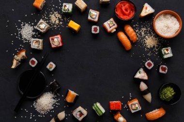 Suşi ve rulo arka plan, siyah, en iyi görünüm, kopya alanı sınırında. Renkli Japon restoranı Mama seti