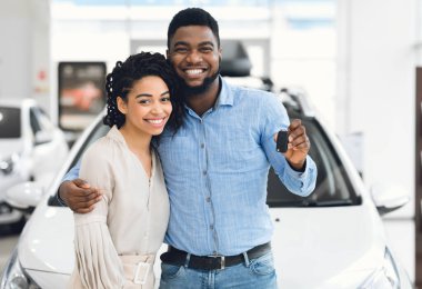 Yeni Otomobil Anahtarı Tutan Afro-Amerikan Çifti Bayilik Merkezi 'nde Yeni Aile Arabası Yakınında Duruyor.