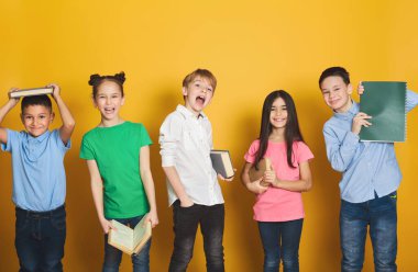 Having oyunculuk ile kitaplar, çocuk kameraya sarı arka plan üzerinde seyir