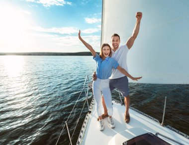 Tekne güvertesinde durup nehirde yaz günü yelkenliyle gezerken eğlenen bir çift. Boş Alan