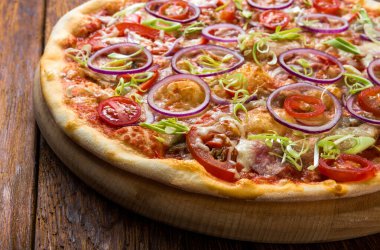 Lezzetli pizza taze soğan, pırasa, pastırma ve kiraz domates - ince pasta kabuk ahşap masa ahşap arka plan, izole