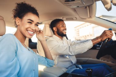 Birlikte seyahat etmekten mutluluk duyarım. Afro-Amerikalı çift araba sürüyor ve gülümsüyor.