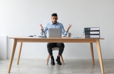 Hata. Kafası karışmış bir Arap 'ın portresi dizüstü bilgisayarlı, omuz silkip el ele tutuşuyor. Uzaktan kumanda. Stresli adam iş sorunları yaşıyor, beklenmedik kötü haberler okuyor.