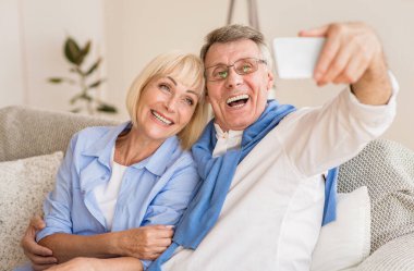 Modern dedeler cep telefonuyla selfie çekiyor, dinleniyor ve evde eğleniyorlar.
