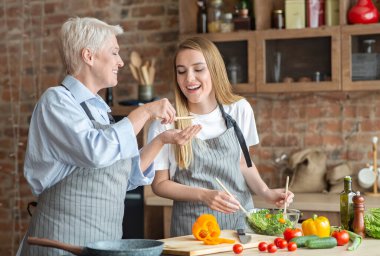 Genç, güzel bir kadın, yaşlı annesine yemek hazırlıyor, mutfağın içini tadıyor, fotokopi çekiyor.