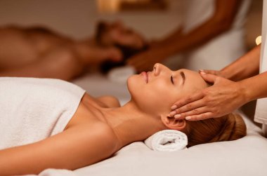 Çift Aküpres Kafa Masajı alıyor. Lüks Spa Merkezi 'nde gözleri kapalı rahatlıyor. Güzellik ve Rahatlama Terapisi, Çiftler Sağlığı ve Gençleştirme Konsepti. Düşük Işık, Seçici Odaklanma