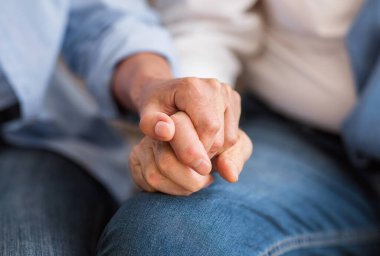 Sevgi ve destek konsepti. Kıdemli çift şefkatle el ele tutuşuyor, yakın çekim