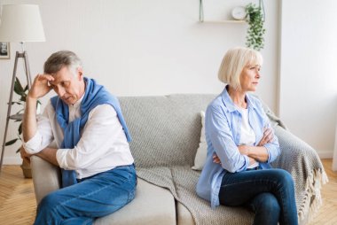 Kanepenin karşı taraflarında oturan yaşlı çift ilişki sorunları yaşıyor.