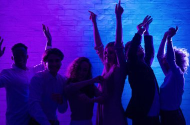 Mutlu Milenyum İnsanları Geceleyin ofiste kurumsal parti vererek dans ediyorlar. Düşük Işık