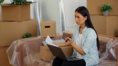 Çinli bir kadın kutularla çevrili bir kanepede oturuyor. Ailesinin taşınması için evrak işleriyle uğraşıyor. Yeni dairelerinin detaylarını yönetmeye odaklanmış..