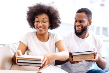 Heyecanlı Kara Eşler, birlikte kutuları paketliyor, yeni daireye taşınıyor, evde oturuyor, taşınma hazırlıkları yapıyor. Genç Aile Konutları, Gayrimenkul Satın Alma ve Sahiplik, Daire Kirası