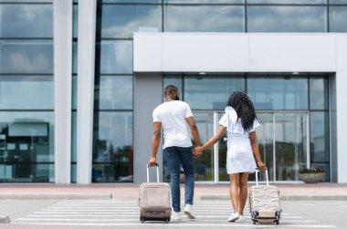 Seyahat ve turizm. Genç çift bagaj, arka görünüm, boş alan ile havaalanı binasına giriyor