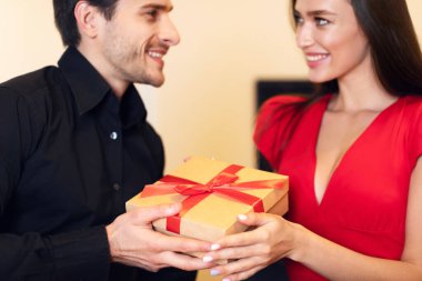 Mutlu aşıkların Noel 'de, yıldönümlerinde, Sevgililer Günü' nde ya da doğum gününde birbirlerine hediye vermeleri. Erkeğinden hediye alan ya da veren mutlu genç bir kadın. Seçici bir şekilde ellerine odaklanıyor.