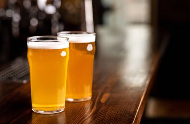 Soğuk, lezzetli içecekler. Bardaki ahşap tezgahta köpüklü iki bardak light bira. Kapatın, boş yer var.