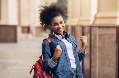 Kutlama yapan neşeli Afrikalı Amerikalı Öğrenci Sınav Sınavı 'nı geçti ve üniversite binasının önünde sırt çantasıyla kameraya gülümsüyor. Başardım, Eğitim Başarı Konsepti