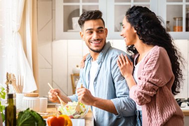 Romantik Orta Doğulu Eşler 'in Mutfakta Birlikte Sağlıklı Yemek Pişirme portresi, Evde Taze Sebze Salatası Hazırlayan Genç Arap Çifti, Lezzetli Vejetaryen Beslenmesinin Tadı, Kopya Alanı