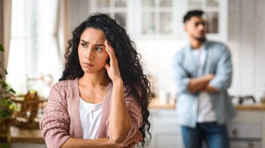 İlişki Krizi. Genç Arap Kadın, kocası ile tartıştıktan sonra, Millennial Ortadoğu çifti mutfakta dikilip, tartışmadan sonra birbirlerini görmezden gelerek, seçici bir şekilde düşünceli bir kadına odaklandı.