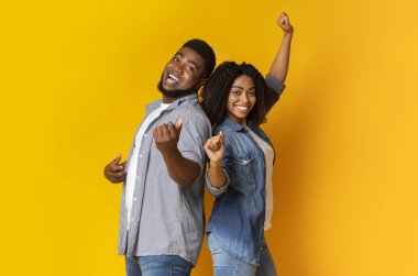 Çift Eğlencesi. Neşeli siyahi adam ve kız dans ediyor ve şarkı söylüyorlar, eğleniyorlar, arka planda kalıyorlar.