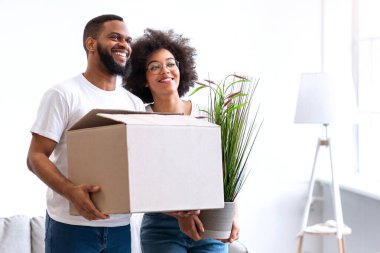 Sevilen siyah çift, paketlenmiş kutular taşınma evi, yeni apartman dairesinde birlikte poz vermek. Genç Aile Konutları, Gayrimenkul Sahipliği Konsepti. Boş Alan