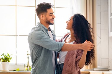 Genç Aile Hayatı. Orta Doğulu eşlerin sıcak mutfak içlerinde dans etmesi, mutlu bir Arap çiftin evde eğlenmesi, birbirlerine bakmaları, gülümsemeleri, birlikte vakit geçirmelerinin keyfini çıkarmaları, uzay kopyalamaları.