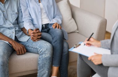 Destek ve Güven. Tanımlanamayan siyah eşler çiftler terapisi seansında birbirlerini teselli ediyorlar. Kırpılmış, Seçici Odaklanma