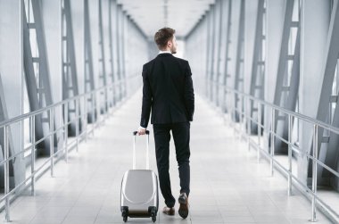 İşe Seyahat. Takım elbiseli bir iş adamının havaalanında bavul taşıdığını gördüm.