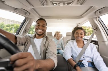 Siyah Ebeveynler ve Kızları Yeni Arabayla Gezintiye Gülümsüyor Kamera Keyifli Yolculuk 'a. Tatil yapan bir aile otomobille seyahat ediyor. Otomobil satın alma konsepti. Seçici Odaklanma