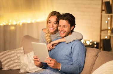 Mutlu eşler Noel hediyelerini tabletle sipariş eder, kış akşamını birlikte geçirirler, boş alan olur.