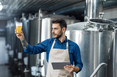 Ürün kalitesi, bira fabrikası ve fabrika yönetimi. Genç işçi ya da önlüklü bir adam tablet kontrolü yapıyor. Büyük kazanları olan, boş yeri olan modern fabrikanın içinde bira rengi.