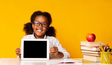 Afro-Amerikalı Liseli Kız Tablet Boş Ekranı Sarı Stüdyo Arkaplanda Oturuyor. Okul ve Eğitim Uygulamaları. Model
