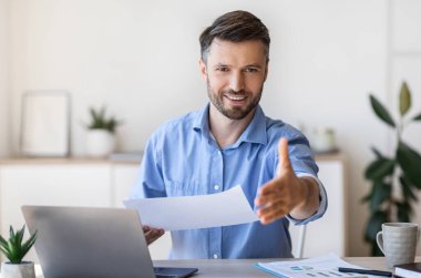 İş görüşmesi için. Arkadaş canlısı yakışıklı erkek İK yöneticisi başarılı toplantıdan sonra el sıkışmak için kameraya elini uzatıyor, boşluğu kopyala