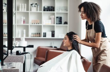 Değişiklik arayan genç bir kadın, güzellik salonunda yeni bir saç stili deniyor, boş bir alan.