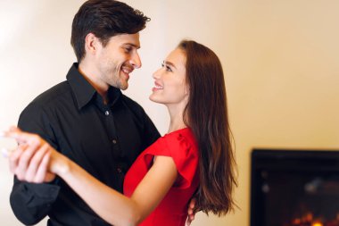 Romance Concept. Portrait of beautiful young couple in love dancing and looking at each other. Smiling bearded man having fun with his pretty excited woman, free copy space. Happy Loving Family