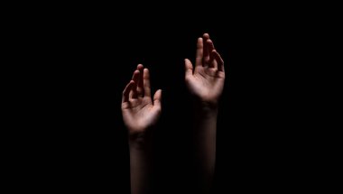 Karanlık, bilinmeyen ya da muhtemelen bir ışık kaynağına uzanan iki el, bir umut ya da çaresizlik hissi uyandırıyor, bir şeye uzanıyor gibi görünüyor..