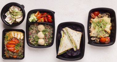 Beyaz arka plan, panorama üzerinde ofiste öğle yemeği için siyah dağıtım kutuları sağlıklı gıda