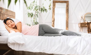 Güzel Koreli kız evde rahat bir yatakta iyi uyuyor. Sağlıklı Uyku Konsepti. Tam Uzunluk