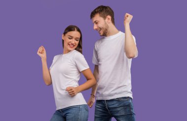 Hayatın tadını çıkarıyorum. Mutlu partnerler dans ediyor ve pastel mor stüdyo arka planında eğleniyor, telif alanı, izole edilmiş