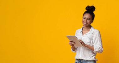 Modern Technologies For Life. Portraif Of Smiling African American Woman Holding Digital Tablet And Looking At Camera, Yellow Background, Panorama