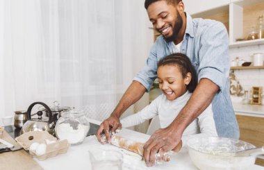 Mutlu afro adam ve onun çocuk kızı birlikte hamur haddeleme, eğlenmek. Ev fırın konsepti, kopyalama alanı